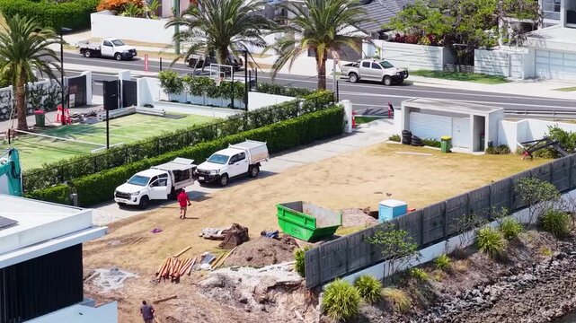 Aerial View of Waterfront Residential Construction Site with Work Vehicles