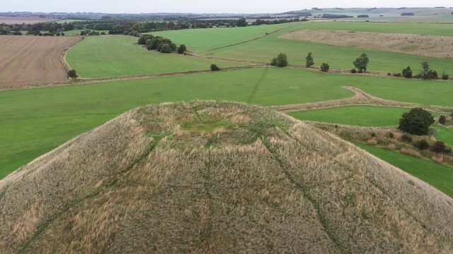 Silbury Hill prehistoric man made chalk and clay mound near Avebury stone circle henge, England. 39m high. Earliest dates from 2400BC. View from SW. Video fly out from top