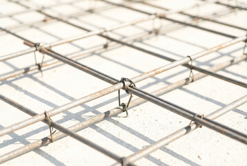 Rebar mesh construction with shadows on concrete floor