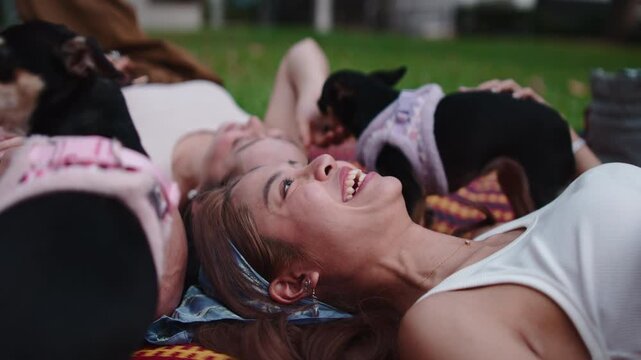 Happy women relaxing in park with dogs