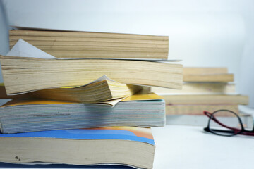 Stack of old used books with worn pages on white background. Concept of education, learning,...