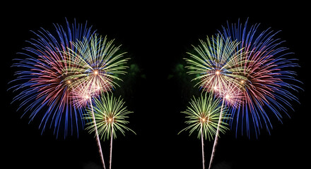 Symmetrical display of colorful fireworks exploding in the night sky