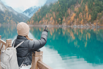 Happy woman traveler travel in jiuzhaigou national park in Sichuan, China. Tourist sightseeing Long...