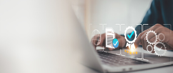 Businessman is reviewing virtual icons on a laptop, representing quality control, business excellence, and certification standards. Focus on ISO, compliance, and top service ratings.