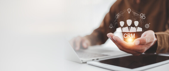 Digital CRM Strategy Businessman Holding Customer Relationship Management System Icon with Business Goals & Technology Sphere .