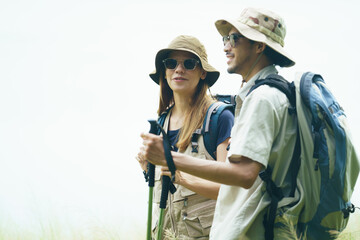 Couple hiking with backpacks near lake. Outdoor adventure and travel lifestyle.