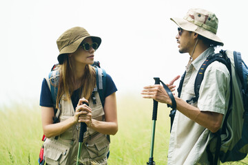 Couple hiking with backpacks near lake. Outdoor adventure and travel lifestyle.
