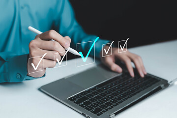 Professional working on laptop using digital pen to complete virtual and business checklist. Concept of task management, online approval, digital workflow, productivity, quality control, remote work,