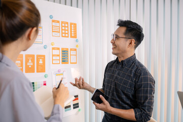 UX/UI designers collaborating during a creative workshop to test interface ideas and exchange...