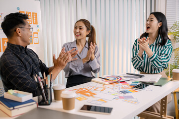 UX/UI designers collaborating during a creative workshop to test interface ideas and exchange feedback for app development, emphasizing teamwork and innovative design thinking.