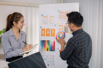 UX/UI designers collaborating during a creative workshop to test interface ideas and exchange feedback for app development, emphasizing teamwork and innovative design thinking.