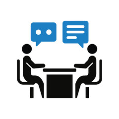 Two people sitting at a table talking to each other