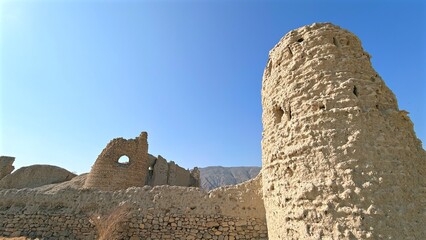 Decaying Structure Imagery, Ancient Ruins Against Bright Sky, Old Fortress Silhouette Under Clear Blue Daytime Sky, Faded Watchtower And Crumbling Walls Evoke Historic Desert Landscape Imagery