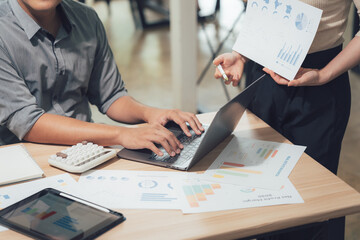 Business analysis in action: A modern office environment where two individuals collaborate over business strategies, and data analysis to meet targets and enhance productivity.