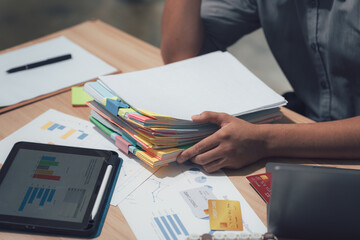 Business Paperwork Examination: A professional meticulously reviews a collection of essential paperwork, symbolizing diligent work ethic and analysis within a business setting. 