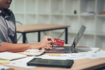 Digital transaction with laptop and credit card: A focused individual securely engages in a digital transaction using a laptop and credit card, representing modern financial activity. 