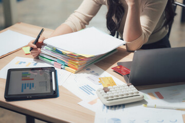 Financial Documentation and Analysis: An individual diligently reviews financial reports, alongside various tools of the trade, creating a picture of focused concentration and serious business.