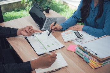 Strategic Meeting: A focused business meeting unfolds, with colleagues collaboratively reviewing documents and exchanging insights over a wooden desk.