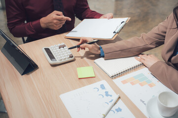 Financial Discussion: A close-up shot captures the intensity of a financial discussion, as a professional meticulously analyzes data and utilizes a calculator.