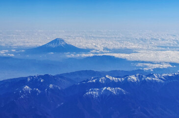 Bird Eye View Wild Angle shot of Fuji Mountain in Japan on Airplan With beautiful blue day with snow on the peak.