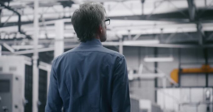 Manager Checking Work Large Scale Data Centre. Professional IT Engineer With Grey Hair Performing Walkthrough of Large Enterprise Server Facility. Concept Facility Supervision and Scale of Operation.