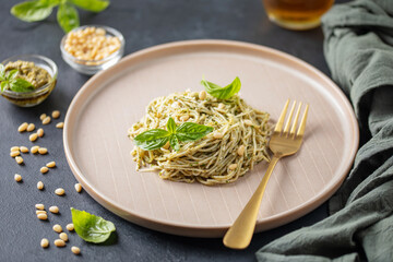 Spaghetti with pesto sauce and  cheese in plate on the table.