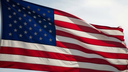 Obraz premium American flag waving in the wind against a bright sky