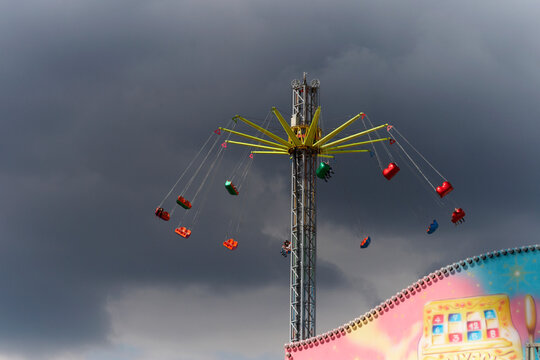 Colorful carousel swing ride at a fair under cloudy sky in Hamburg