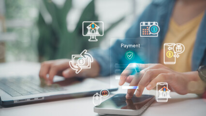 Close up of hand using smartphone and laptop for Digital Payment with secure fintech hologram interface, featuring online banking, money transfer and transaction icons for cashless society concept.