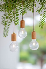 close-up of hanging light bulbs with wooden accents on green leaves and a blurred background.