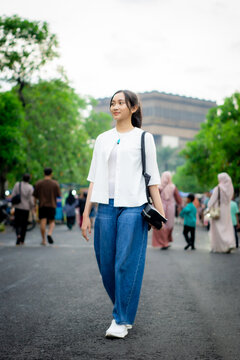 A cheerful Asian woman traveling alone and enjoying the atmosphere. Without any friends.