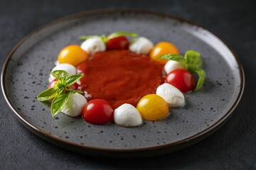 Caprese salad with tomato sauce on a plate on the table.