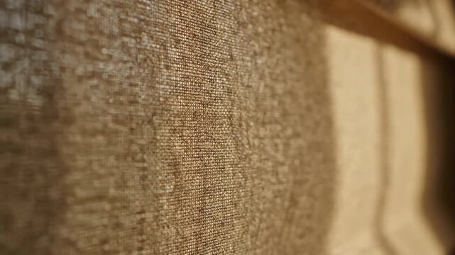 Abstract detail of textured brown textile fabric with shadows and natural sunlight.