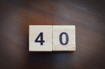 Close-up of number 40 on rustic wooden tiles, perfect for celebrations, anniversaries, and milestone events.