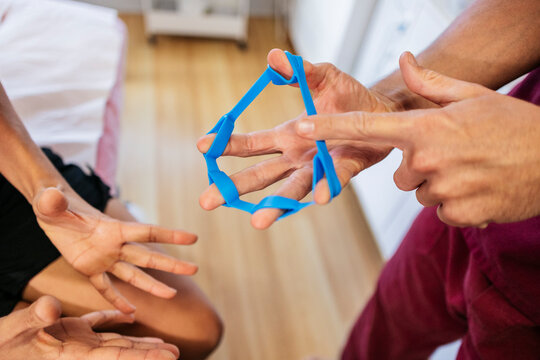 Physiotherapist using resistance band for hand therapy exercise