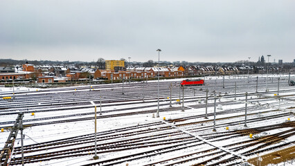 Railway lines, train tracks covered with snow aerial drone view, railway in the Netherlands in winter, transport disruption due to winter weather problems and heavy snow