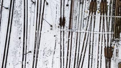 Railway lines, train tracks covered with snow aerial drone view, railway in the Netherlands in winter, transport disruption due to winter weather problems and heavy snow