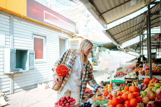 Woman shopping at vegetable market on a sunny day