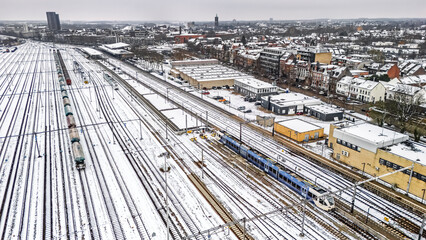 Railway lines, train tracks covered with snow aerial drone view, railway in the Netherlands in winter, transport disruption due to winter weather problems and heavy snow