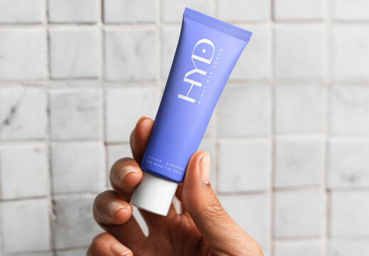 Hand Holding Blue Skincare Tube Mockup PSD