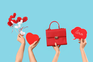 Female hands with hearts, bag and speech bubble on blue background. Valentine's Day celebration