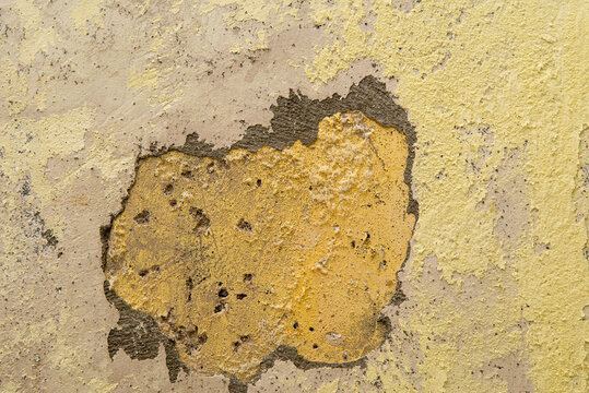 Damaged wall showing peeling paint, saltpeter, texture, and underlying plaster.