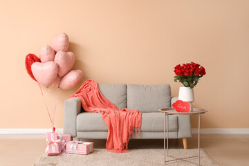 Interior of living room decorated for Valentine's Day with sofa, table and balloons