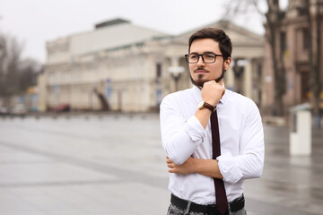 Fototapeta premium Thoughtful businessman in eyeglasses on city square