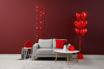 Interior of living room decorated for Valentine's Day with sofa, tables and balloons