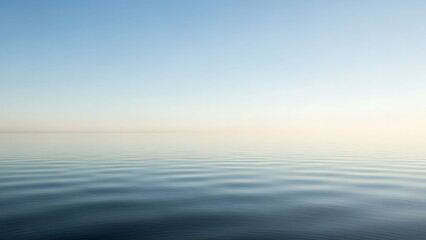 Obraz premium Peaceful ocean waves under serene blue sky with soft sunrise light