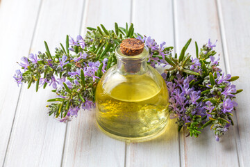 Rosemary herbal essential oil on the wooden background