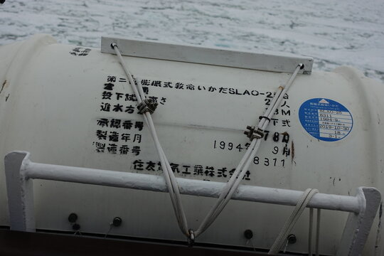 White inflatable life raft canister on ship deck.