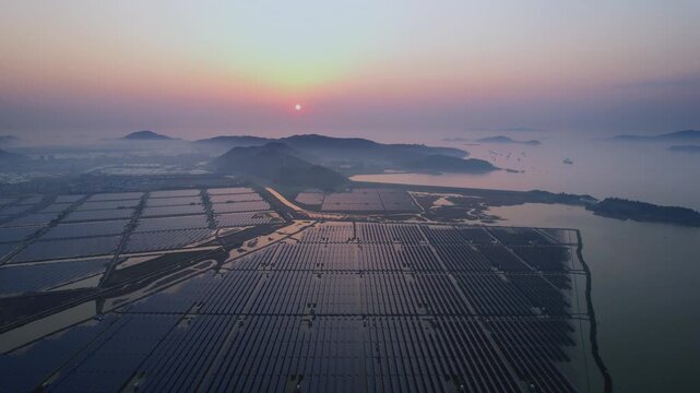 Solar power station on the sea at sunset with distant mountains and coastal landscape