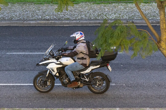 Biker riding benelli trk 502 motorcycle on city street
